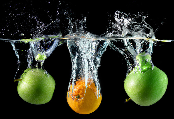 Splash water with droping oranges and apples - 写真・画像