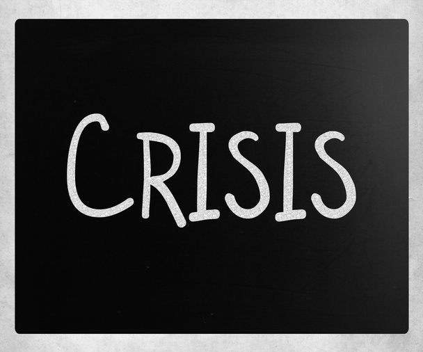 "Crisis" handwritten with white chalk on a blackboard - Photo, Image