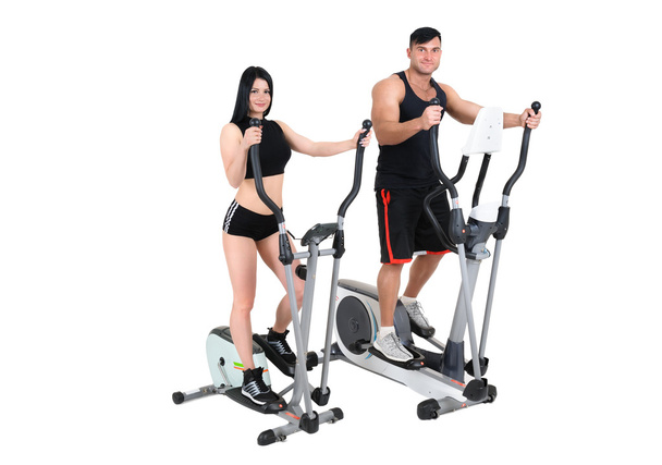 junge Frau und Mann machen Übungen auf Crosstrainer - Foto, Bild