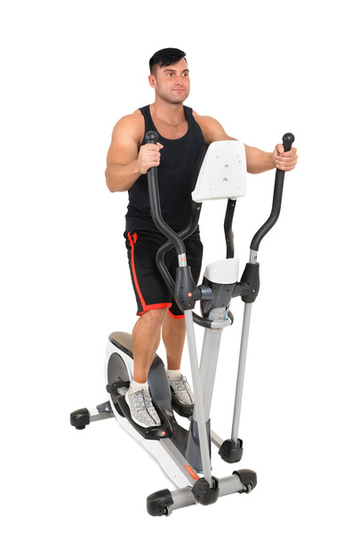 young man doing exercises on elliptical cross trainer - Photo, Image