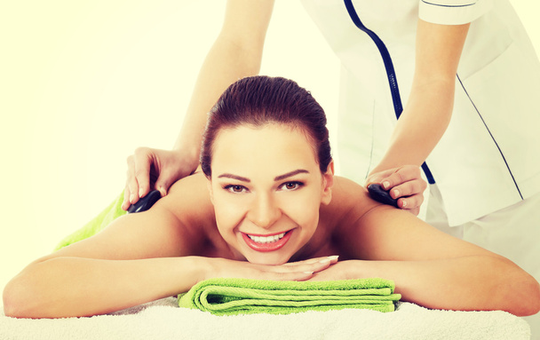 Beautiful woman on spa salon having stone massage. - Fotó, kép