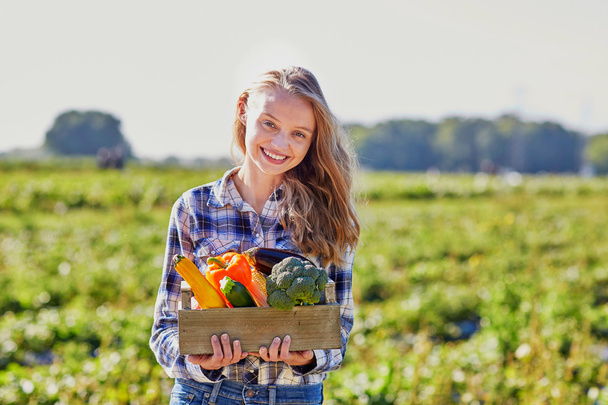 Woman with wooden crate of vegetables - Foto, Bild