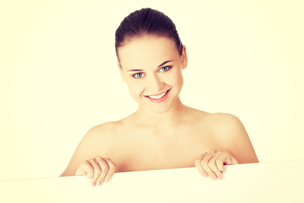 Mulher com pele perfeita segurando placa em branco
 - Foto, Imagem