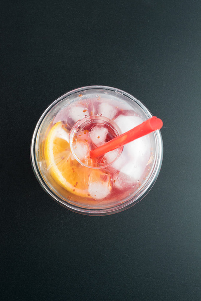 Cranberry ital, jég, a narancs és a citrom, a fekete háttér.  - Fotó, kép