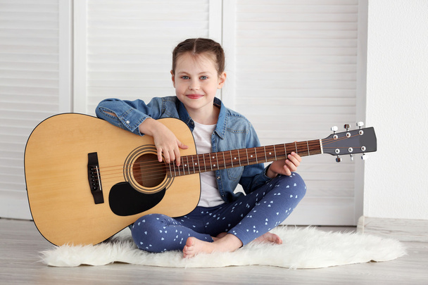 Little girl playing guitar  - Фото, зображення