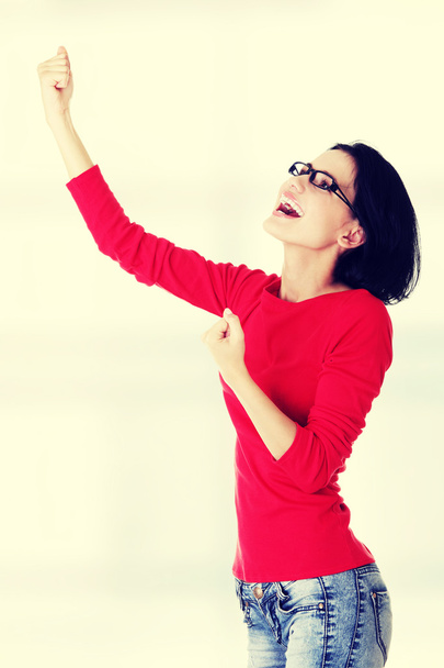 Mujer joven emocionada con los puños en alto
 - Foto, imagen