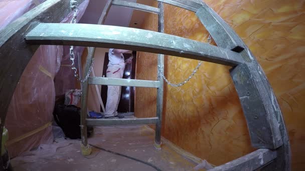 Pintor en el trabajo con escalera de madera en primer plano
 - Metraje, vídeo