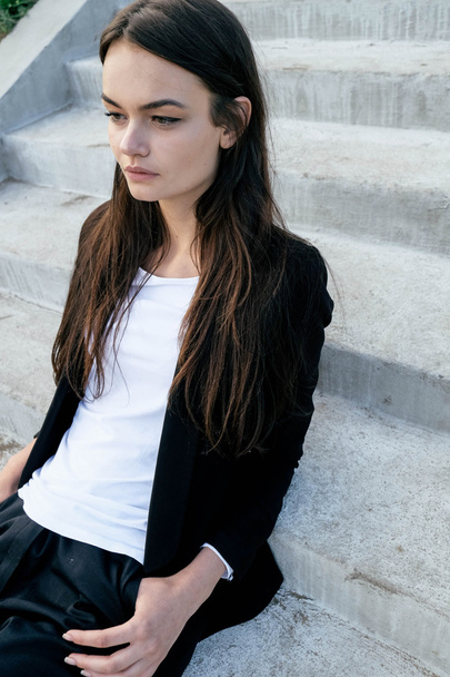 Beautiful young girl on a city street. Dressed in men's style - Photo, Image