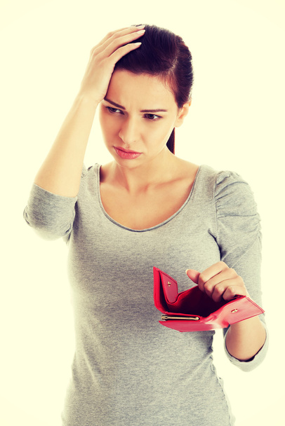 Beautiful casual woman with empty wallet, worrying. - Фото, изображение