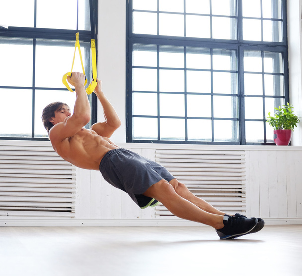 Mannelijke trainen met fitness trx riemen - Foto, afbeelding