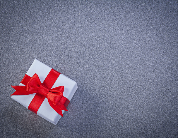 White boxed present with red tied bow on grey surface holidays c - Fotoğraf, Görsel