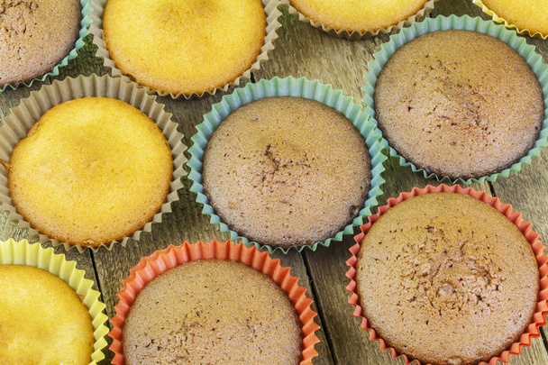 Kotitekoiset muffinit kahdella värillä pöydällä
  - Valokuva, kuva