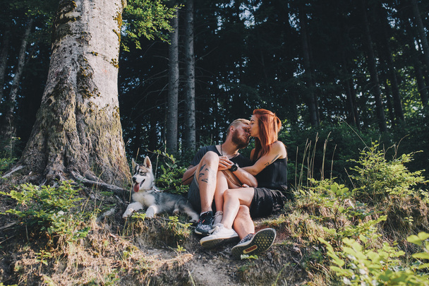 красивая пара сидит в лесу рядом с деревом
 - Фото, изображение