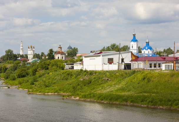 Verkhoturye, Russia - June 18, 2016: Stone buildings with towers and domes, located on the banks of the river, different architecture and construction time. Verkhoturye - the spiritual center of the Urals. There are several monasteries and many churc - 写真・画像