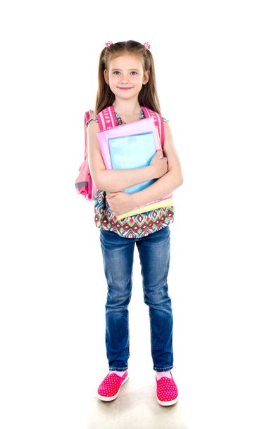 Portrait of smiling schoolgirl with books and backpack isolated - 写真・画像