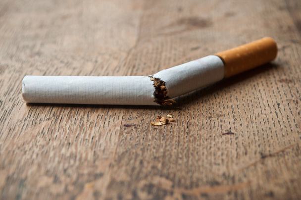 stop cigarette concept - closeup of cigarette broken on wooden table background - Foto, Imagen