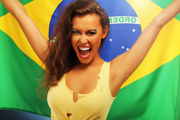 Happy Brazilian fan cheering with flag - Foto, afbeelding