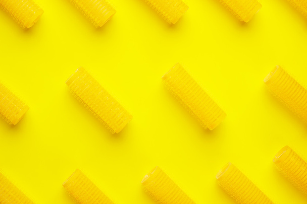 hair curlers on yellow background - Foto, afbeelding