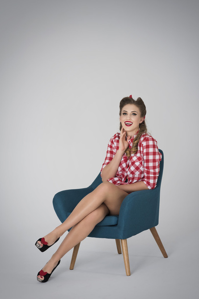 Pin up girl resting in blue armchair - Фото, изображение