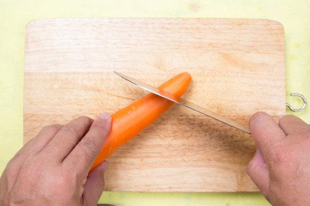 Chef coupe carotte sur une planche en bois
 - Photo, image