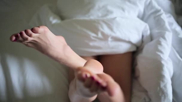 Girls legs lying in white blanket - Imágenes, Vídeo