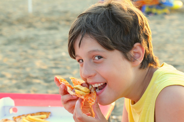 Çocuk mozzarella peyniri ve patates kızartması pizza yiyor - Fotoğraf, Görsel