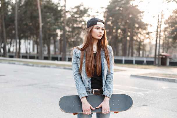 Beautiful stylish girl hipster with skateboard on a sunny day - Photo, Image