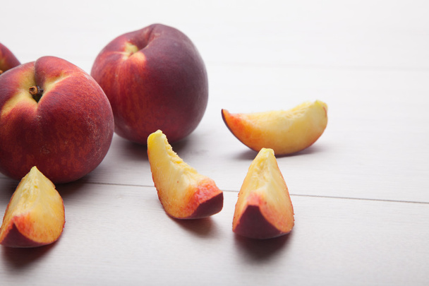 ломтики персиков на белом столе
 - Фото, изображение