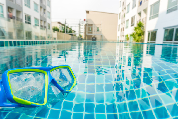 Máscara de mergulho na piscina backgeound com condomínio, óculos e piscina
 - Foto, Imagem