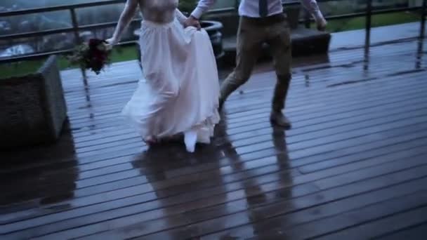 Couple running on a wet wooden floor - Materiał filmowy, wideo