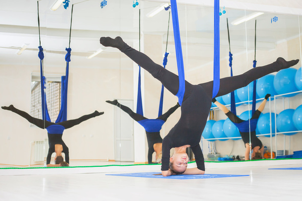 Young women doing aerial yoga exercise or antigravity yoga - Фото, изображение