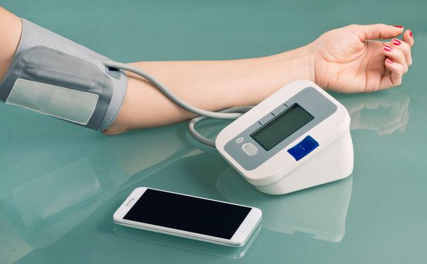 Mujer midiendo la presión arterial - Foto, Imagen