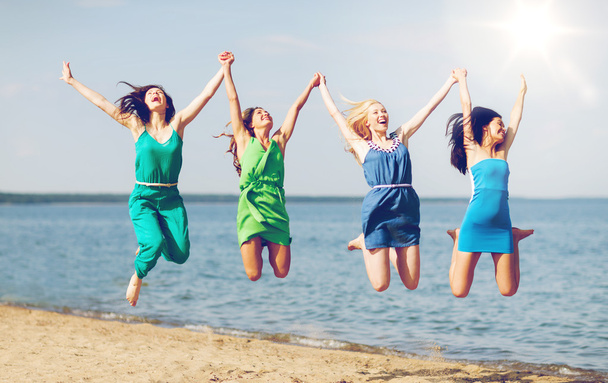 meisjes springen op het strand - Foto, afbeelding