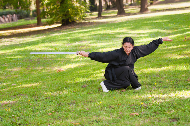 Vrouwelijke Kung Fu zwaard beoefenaar - Foto, afbeelding
