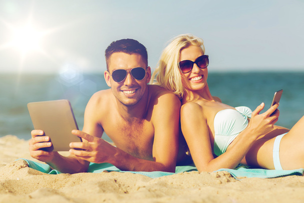 happy couple with tablet pc sunbathing on beach - Fotoğraf, Görsel