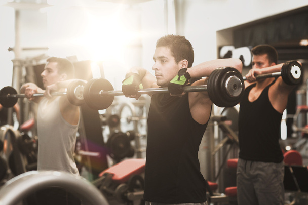 group of men with barbells in gym - Foto, afbeelding