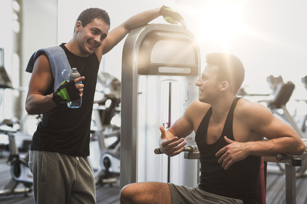 smiling men exercising on gym machine - Φωτογραφία, εικόνα