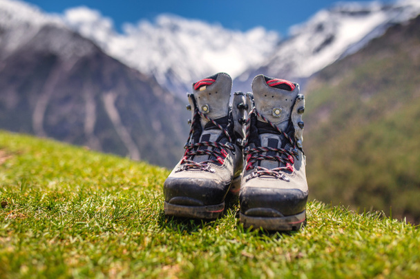 Oude hiking schoenen en Alpine landschap op de achtergrond - Foto, afbeelding