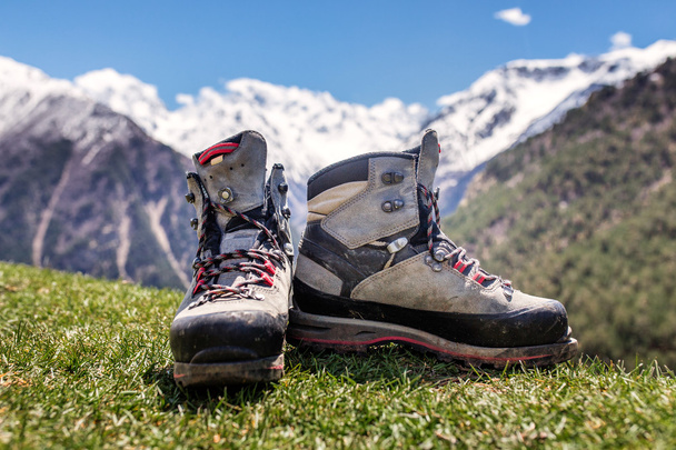 Oude hiking schoenen en Alpine landschap op de achtergrond - Foto, afbeelding