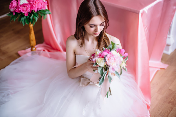 young beautiful bride with a bouquet of pink peony - Foto, imagen