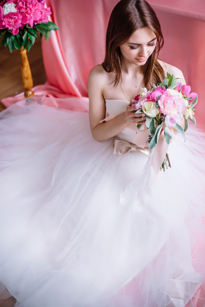 young beautiful bride with a bouquet of pink peony - Foto, afbeelding