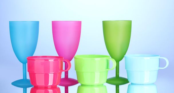 Bright plastic tableware on blue background - Zdjęcie, obraz