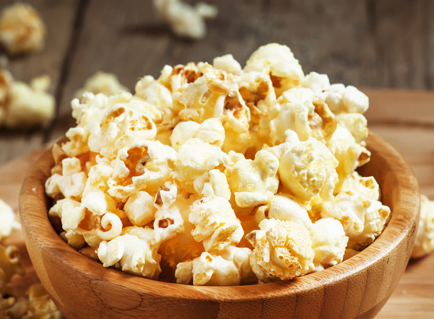 Sweet caramel popcorn in a wooden bowl - Photo, image