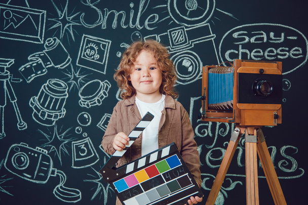 Little boy standing near the camera against a black background with the words - Zdjęcie, obraz