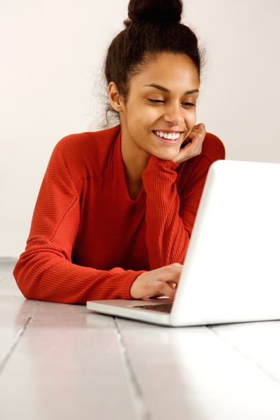 усміхнена молода жінка використовує ноутбук
  - Фото, зображення