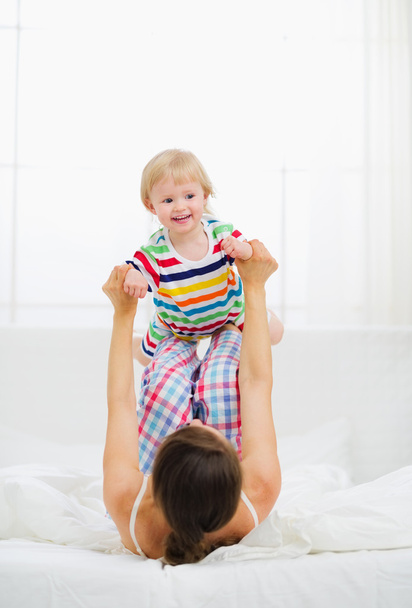 Mother playing with baby in bedroom - 写真・画像