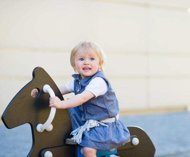 Baby swing on horse on playground. Side view - Foto, imagen