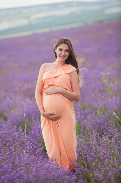 Lavendel veld en een gelukkig zwangere vrouw - Foto, afbeelding