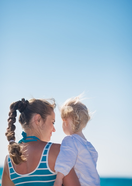 Portrait of mother and baby on beach. Rear view - Photo, image