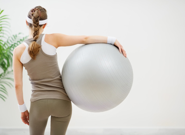 Athletic woman with fitness ball standing back to camera - Φωτογραφία, εικόνα